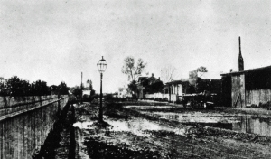 Early 1870s photo of San Pedro Street in Los Angeles. The focus of the photograph was the gas streetlight, not the condition of the street which was, evidently, normal. Photo from the California Water and Power Association’s online museum, used with permission.